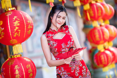 Midsection of woman holding red lantern