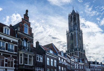 Low angle view of buildings against cloudy sky