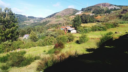 Scenic view of green landscape and mountains against sky