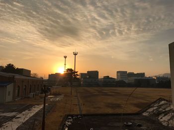 Factory against sky at sunset