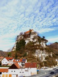Buildings in city against cloudy sky