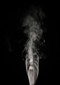 Close-up of woman against black background