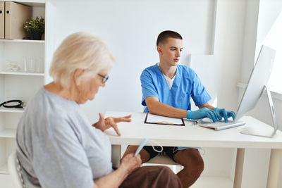 Side view of doctor examining patient in office
