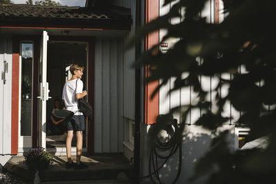 Boy standing with badminton in back yard