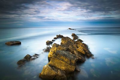 Rocks on beach against sky