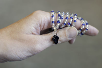 Cropped hand of woman holding necklace