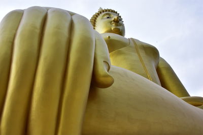 Low angle view of statue of buddha against sky