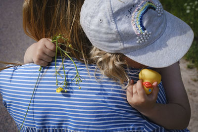 Midsection of woman holding girl outdoors