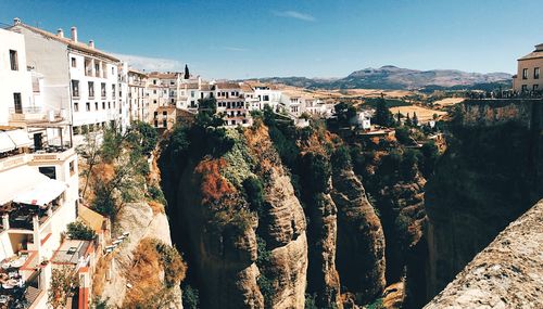 High angle view of residential district on cliff against blue sky