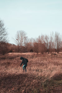 Rear view of man on field against clear sky