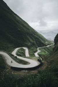 Scenic view of winding road on mountain against sky