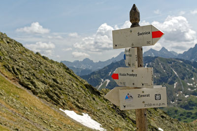 Close-up of road sign against sky