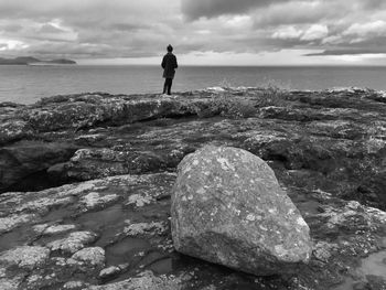 Rear view of man on beach against sky