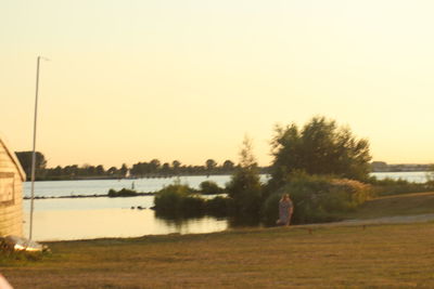 Scenic view of lake against clear sky during sunset