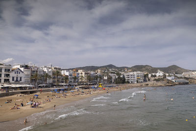 Scenic view of beach by buildings against sky