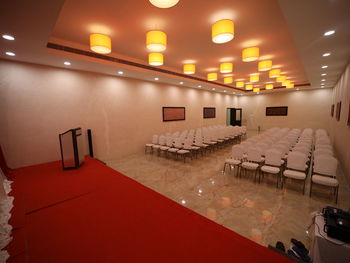 Empty chairs and tables in illuminated room