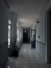 Rear view of man walking in corridor of building