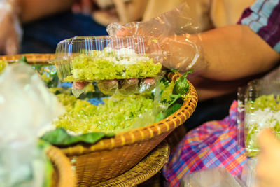 Close-up of man preparing food in basket