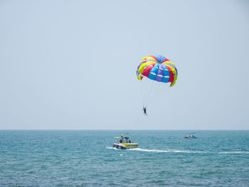 People in sea against clear sky