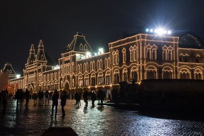 Group of people in illuminated city at night