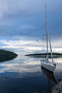 Sailboats moored in lake against sky