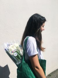 Young woman standing against wall