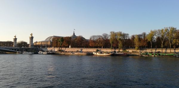 Boats in river against buildings in city