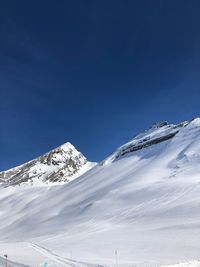 Snowcapped mountains against blue sky