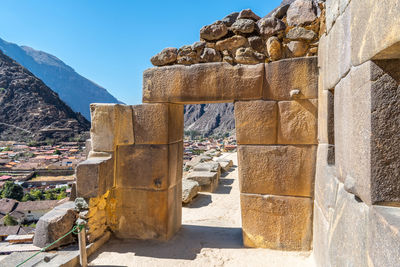 Stone doorway at ollantaytambo ruins, peru against blue sky 