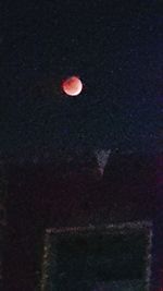 Close-up of red moon at night