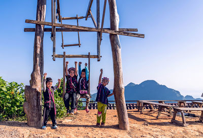 People at traditional windmill against sky