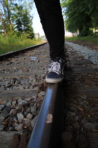 Low section of person standing on railroad track