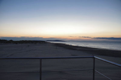 Scenic view of sea against clear sky at sunset