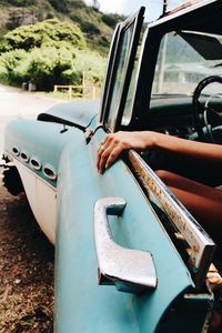 Close-up of hand holding car door