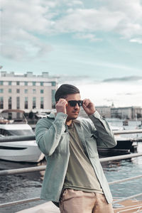 Side view of young man standing against sea