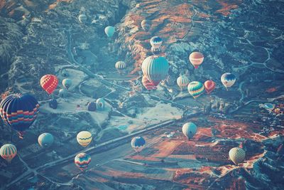 High angle view of hot air balloons flying over landscape