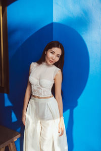 This stunning photograph captures a radiant asian bride in a unique white wedding dress-trouser suit