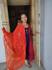 Portrait of young woman standing at door