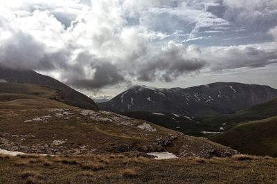 Scenic view of mountains against cloudy sky