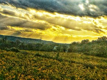 Scenic view of field against dramatic sky