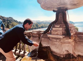 Side view of young man against sky