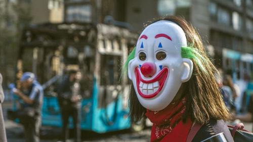 Close-up of woman wearing clown mask in city