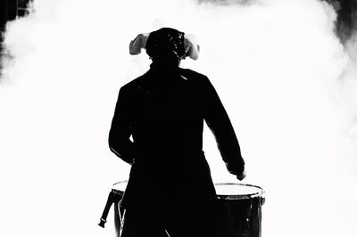 Rear view of man standing against white background