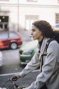 Portrait of young woman sitting on street