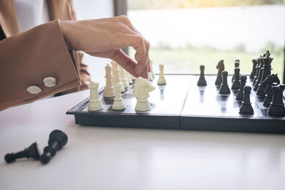 Midsection of businessman playing on chess board