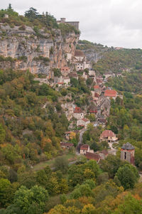 Townscape by tree mountain against sky