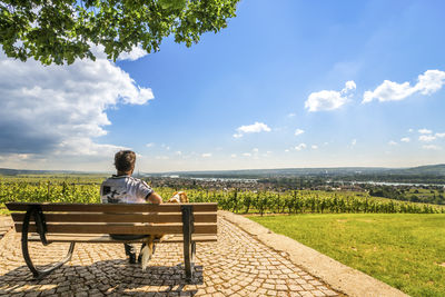 Rear view of man sitting on bench