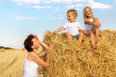 Side view of girl sitting on hay