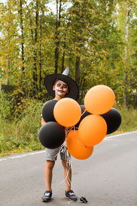 Full length portrait of woman holding balloons