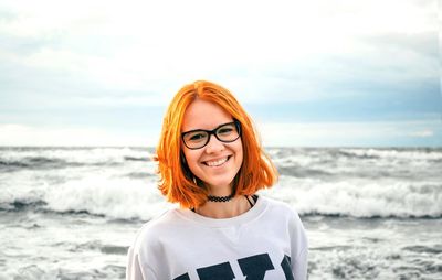 Portrait of young woman wearing sunglasses at beach